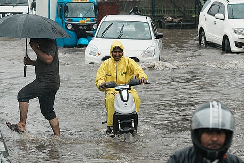 Motorist rides through a waterlogged road